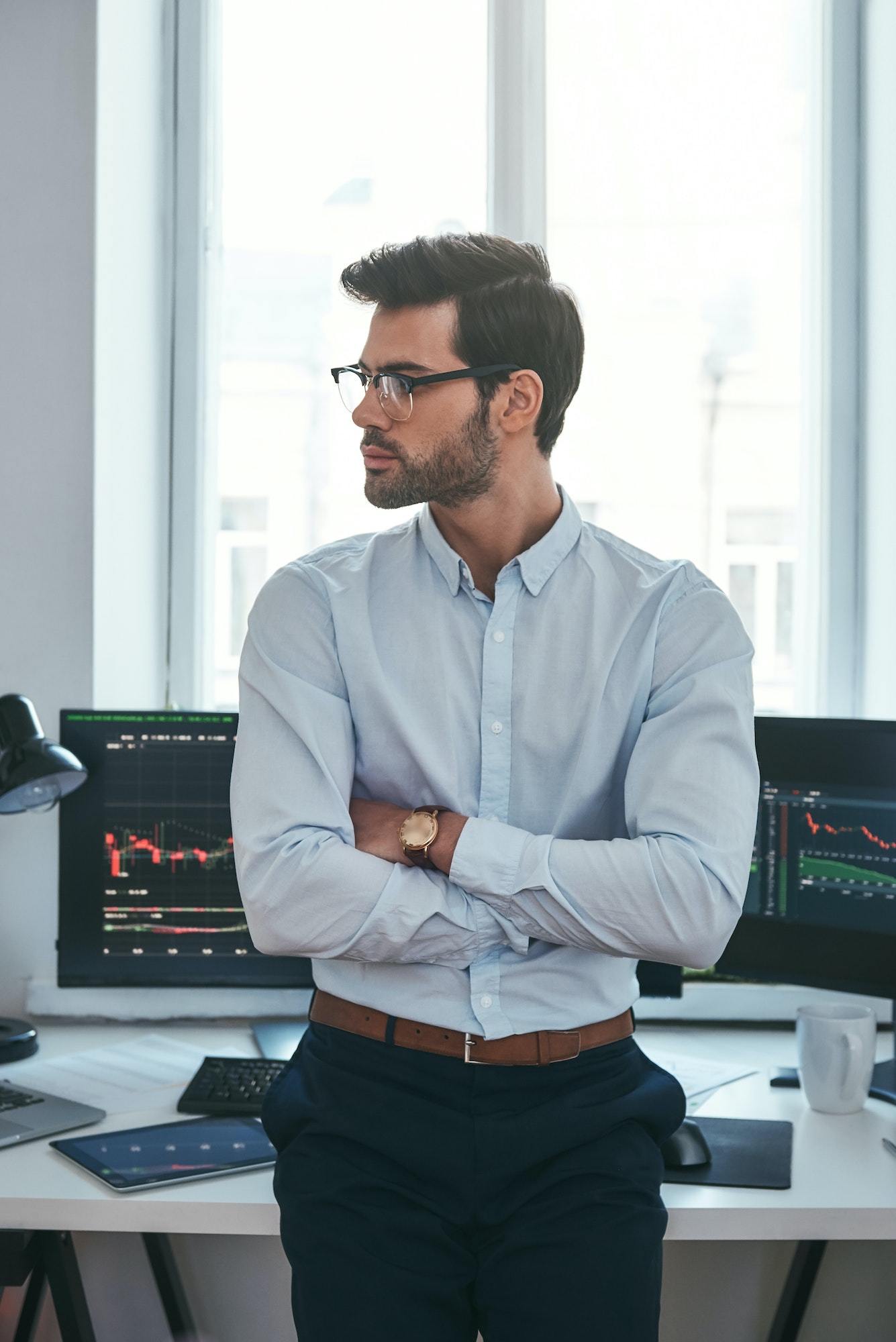Young and smart. Vertical photo of confident businessman or trader in formal clothes and eyeglasses